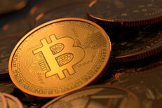 Random assortment of Bitcoins with soft golden light focused on one coin