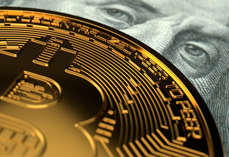 Close-up photo of Bitcoin detail with Benjamin Franklin currency eyes behind it