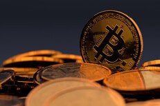 Random pile of Bicoins with one Bitcoin standing vertically