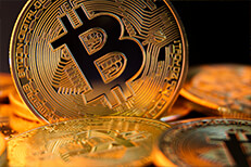 Close view of a bitcoin on edge in a pile of bitcoins