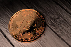 Single Bitcoin placed on weathered boards