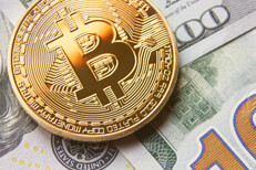 Close view of bitcoin on scattered 100 dollar bills