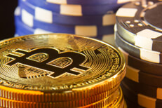 Stack of bitcoins with stacks of blue and black poker chips