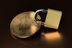 Bitcoin secured with padlock on reflective metallic surface