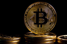Bitcoin on top of coin stack Bitcoin on edge on top of a stack of Bitcoins