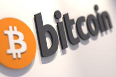 Bitcoin logo on a white painted wall
