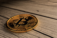Single Bitcoin lying on old weathered faded wood planks