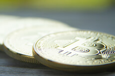 Bitcoins laid on wood with short depth of field and nature bokeh background