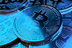 Bitcoins illuminated blue Pile of random Bitcoins illuminated by two blue lights symbolizing price decline or a bear market