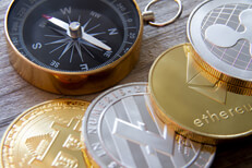 Row of crypto coins with compass Bitcoin, Litecoin, Ethereum, and Ripple coins with navigational compass