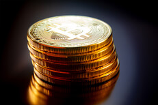 Leaning stack of bitcoins soft light Leaning stack of bitcoins on reflective textured surface with soft back light