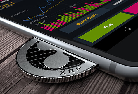iPhone with Ripple XRP coin inserted into slot concept for mobile XRP apps, profits, or trades