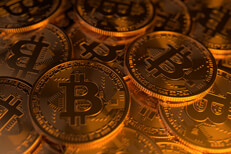 Large pile of random Bitcoins Large random pile of Bitcoins illuminated with soft golden light from side
