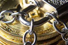 Close up photo of a stack of Bitcoins secured by chains and a padlock