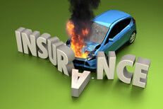 Car fire insurance claim concept Car insurance concept photo of blue car on fire crashed into stone letters spelling INSURANCE