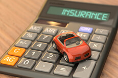 Insurance calculator with toy car Wood table with calculator with LCD reading Insurance with red toy car on top