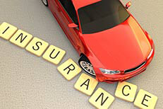 Auto insurance accident concept image Red car sliding and displacing several wooden letters spelling insurance