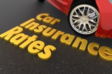 Car insurance rates Insurance concept image showing car insurance rates text on blacktop road next to red sports car