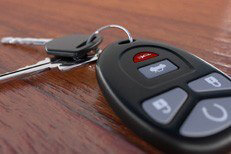 Car keys and clicker on desk Closeup image of car keys and key fob on wooden desk