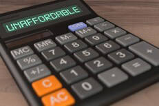 Unaffordable car insurance calulator Calculator with LCD showing word Unaffordable to illustrate high price concept