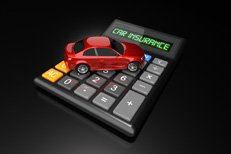 Red car sitting on calculator with LCD words Car Insurance