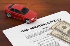 Cost of car insurance concept Car insurance policy on desk with small toy car and one hundred dollar bills