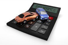 Two car accident on top of insurance calculator isolated on white