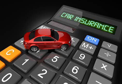Small red toy car on car insurance calculator on dark background