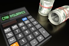 Calculator with LCD reading Car Insurance with two rolls of one hundred dollar bills