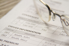 Car insurance bill with glasses Car insurance policy billing notice with reading glasses