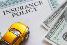 Toy car with insurance policy and money Yellow toy car on insurance policy with two 100 dollar bills car insurance concept
