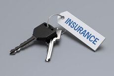 Car keys with insurance tag isolated on gray background