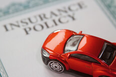 Red car on insurance policy Red car on an insurance policy certificate with focus on the car and short depth of field