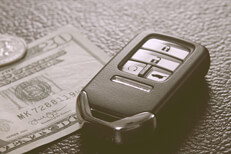 Key fob with money on shiny leather background