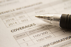 Car insurance policy showing coverages with ink pen