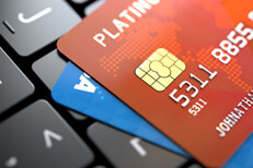 Two credit cards on dark laptop keyboard at angle concept for online purchase or credit report