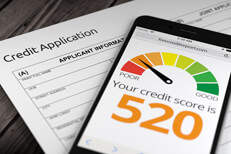 Credit application bad credit Paper credit application on wood desk with cell phone showing poor credit rating of 520