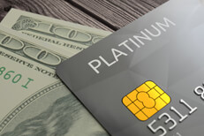 Cash with credit card Photo of credit card with EMV chip resting on top of two one hundred dollar bills