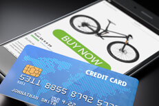 iPhone showing buy now button with blue credit card lying on screen