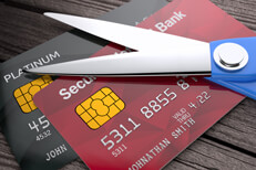 Too many credit cards Two credit cards on weathered wood planks with scissors