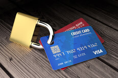 Photo of two credit cards padlocked on old wood surface