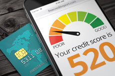 Cell phone screen showing poor credit rating on top of credit card with EMV chip