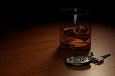 DUI concept of drink and keys Drunk driving concept showing alcoholic drink on bar with car keys in foreground