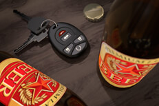 Beer bottles on dark bar with keys Beer bottles on dark wood bar with car keys and bottle cap symbolizing drunk driving