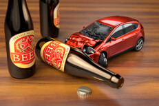 Car crashing into beer bottles on bar Small car crashing into a beer bottle on bar top