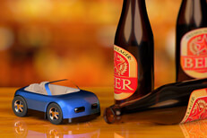 Small blue toy car with beer bottles on bar concept for DUI or drunk driving