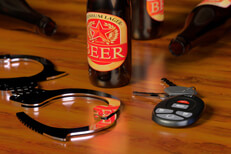 Handcuffs and beer with keys Shiny handcuffs with car keys and beer bottles on bar DUI concept image