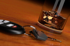 Drunk driving concept showing whiskey glass and car keys on bar top at angle
