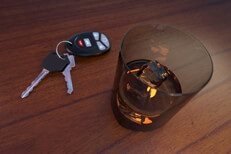 Glass of whiskey and car keys on bar Drunk driving concept showing a glass of whiskey and car keys sitting on a bar