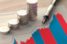 Coin stacks and pen on market returns Paper showing stock historical stock market returns with stacks of coins and pen